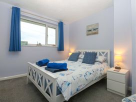 A bedroom with a double bed and window at Pebbles Reach in Colwyn Bay