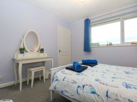 A bedroom with a bed and vanity at Pebbles Reach in Colwyn Bay
