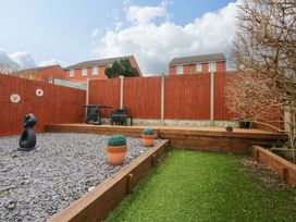 A garden with a table and chairs at Pebbles Reach in Colwyn Bay
