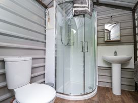A bathroom with toilet shower and sink with mirror at Shepherd's Hut in Scarborough