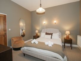 A bedroom with a bed, bedside tables, and a chair at The Park in Ludlow