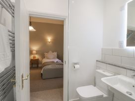 A bathroom with a sink and toilet leading to a bedroom at The Park in Ludlow