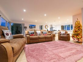 A living room with a sofa and a Christmas tree at Atlantic View in Germoe