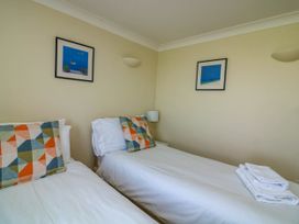 A bedroom with two single beds with white sheets and patterned pillows at 4 Thurlestone Beach House South Milton near Thurlestone