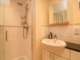 A bathroom with a shower area and a sink with a mirror cabinet above at 4 Thurlestone Beach House South Milton near Thurlestone