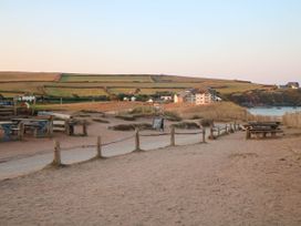 A sandy path with wooden fences and benches overlooking fields and houses near the coast at 4 Thurlestone Beach House in South Milton near Thurlestone