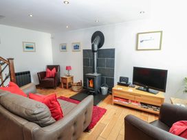 A living room with a fireplace and television at Chapel Cottage in Sandford, Cumbria