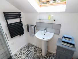 A bathroom with a sink and towel rack at Chapel Cottage in Sandford, Cumbria