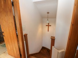A staircase with a lamp and cross at Chapel Cottage in Sandford, Cumbria