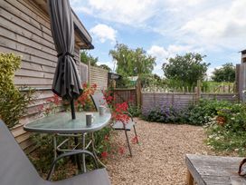 A garden with a table and chairs at Tiny Willow in Farrington near Child Okeford