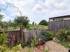 A garden with flowers and an archway at Tiny Willow in Farrington near Child Okeford