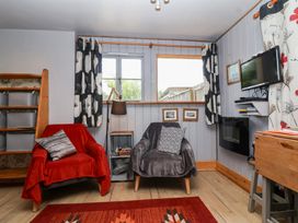 A living room with two armchairs and a shelf at Tiny Willow in Farrington near Child Okeford