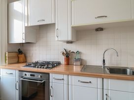 A kitchen with a gas stove and sink at 2 York House in Dartmouth