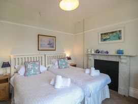 A bedroom with two single beds and a fireplace at 2 York House in Dartmouth