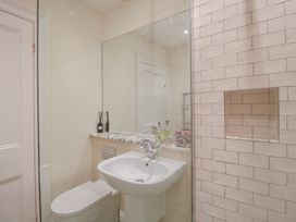 A bathroom with a sink, toilet, and mirror at 2 York House in Dartmouth