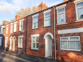 A row of brick terraced houses with white framed windows and arched doorways on a street at 202 Salisbury Terrace in York