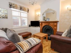 A living room with leather sofas a wooden coffee table a fireplace and a TV at 202 Salisbury Terrace York