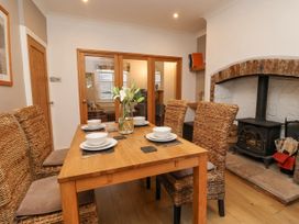 A dining room with a wooden table set for four and a wood stove fireplace at 202 Salisbury Terrace in York