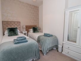 A bedroom with two single beds green blankets and a white wardrobe with mirror at 202 Salisbury Terrace in York