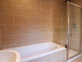 A bathroom with a bathtub a shower enclosure and tiled walls at 202 Salisbury Terrace in York