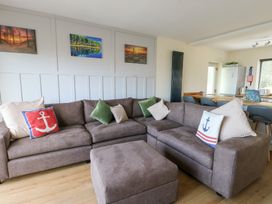 A living room with a sectional sofa and wall art at Daisy Cottage in Benllech