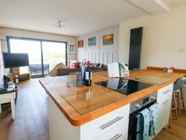 A kitchen with an island and seating area at Daisy Cottage Benllech