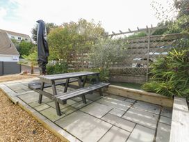 A garden with a picnic table and plants at Daisy Cottage in Benllech