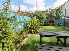 A garden with a table and plants at Daisy Cottage in Benllech