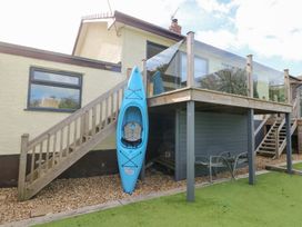 An outdoor area with a kayak, staircase, and seating at Daisy Cottage Benllech