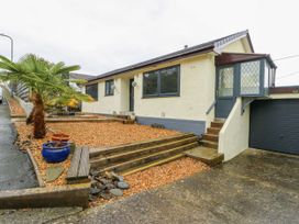 A house with steps and a palm tree at Daisy Cottage in Benllech