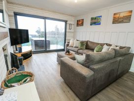 A living room with a sofa and a television at Daisy Cottage in Benllech