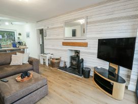 A living room with a sofa and television at Daisy Cottage in Benllech