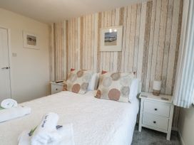 A bedroom with a double bed and nightstands at Daisy Cottage in Benllech