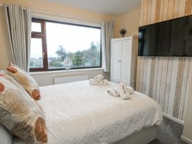 A bedroom with a bed and a television at Daisy Cottage Benllech