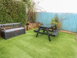 A garden with a bench and picnic table at Daisy Cottage, Benllech