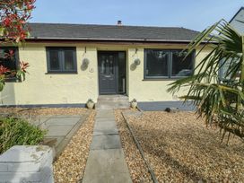 A front entrance with a pathway and garden at Daisy Cottage in Benllech