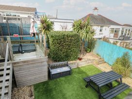 A garden with a hot tub and seating area at Daisy Cottage in Benllech