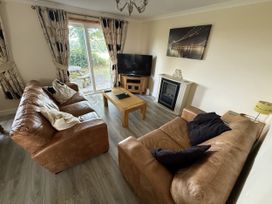A living room with sofas and a television at Hembry Meadows in Honicombe Park near Gunnislake