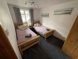 A bedroom with two single beds and a window at Hembry Meadows Honicombe Park near Gunnislake