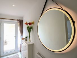 A hallway with a mirror and flower vase at Little Starboard in Kingsbridge