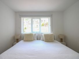 A bedroom with a bed, nightstands, and a window at Little Starboard in Kingsbridge