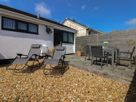 A garden with sun loungers and a dining table at Little Starboard in Kingsbridge