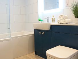 A bathroom with a bathtub and sink at Honeybee Cottage in Penruddock