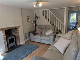 A living room with a fireplace and sofa at Melita in Curry Rivel