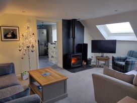 A living room with a fireplace and television at Coast View in Hartland