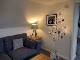 A living room with a couch and decorative tree at Coast View in Hartland