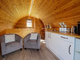 A kitchen with seating and cabinets at Embden Pod at Banwy Glamping Llanfair Caereinion