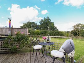 An outdoor seating area with a table and chairs at Embden Pod at Banwy Glamping Llanfair Caereinion