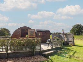A wooden pod with decking and garden space at Embden Pod at Banwy Glamping Llanfair Caereinion