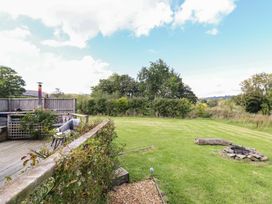 A garden with a fire pit and seating area at Embden Pod at Banwy Glamping in Llanfair Caereinion
